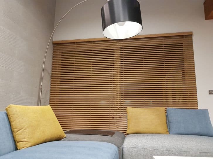 Żaluzje drewniane na wymiar w oknach salonu